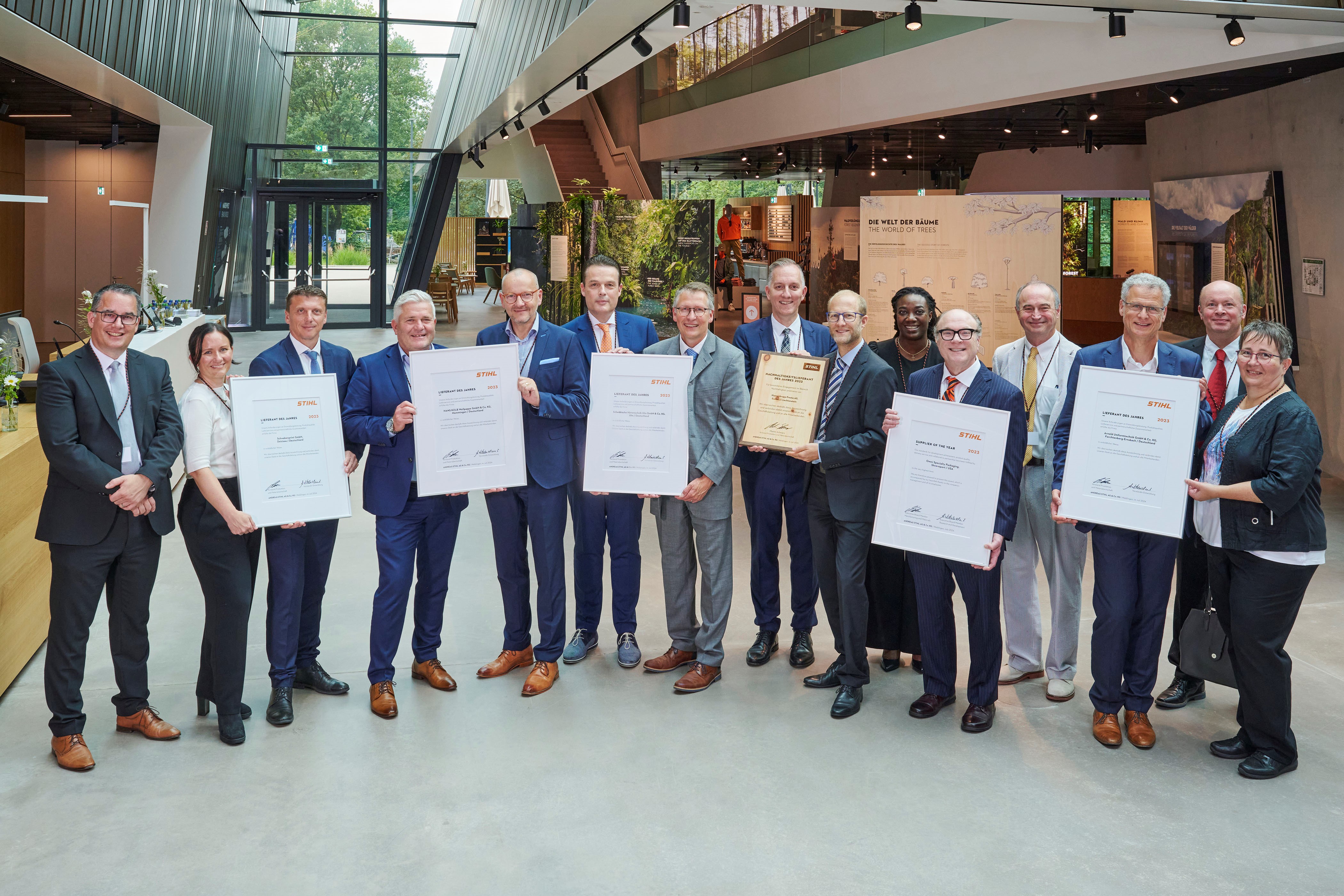 Martin Schwarz, membro del consiglio direttivo STIHL per la produzione e i materiali (a sinistra), e Marc Moser, vicepresidente degli acquisti (dietro a destra), con i fornitori premiati nel mondo del marchio STIHL.